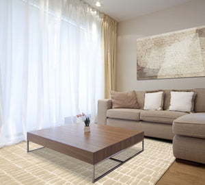 Tapis design beige aux contours irréguliers en laine et viscose, intégré dans un salon contemporain lumineux