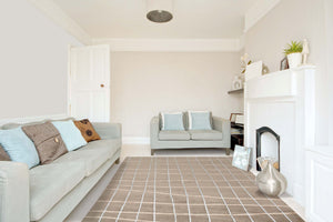 Tapis contemporain taupe aux formes organiques et touches colorées, intégré dans un salon élégant et chaleureux