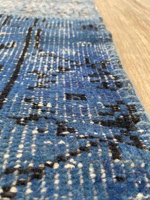 Tapis carré patchwork recyclé en laine et coton bleu vert beige présenté de bord