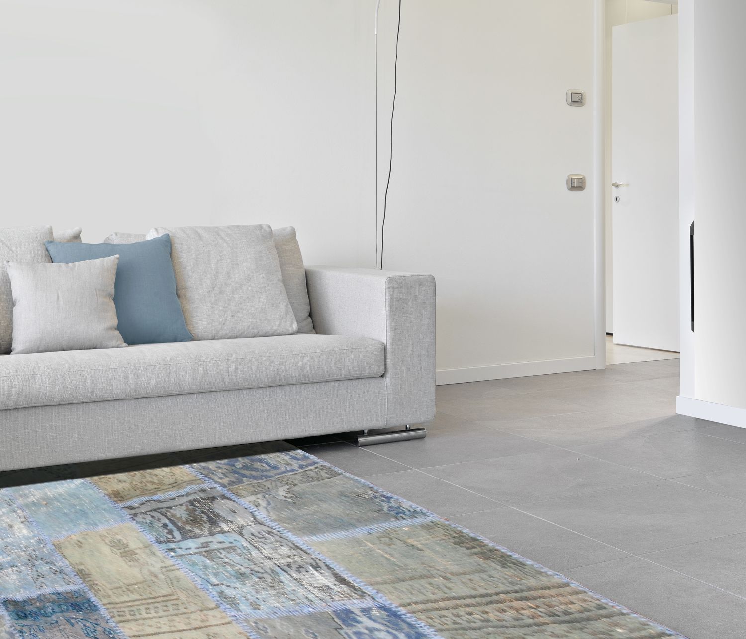 Tapis carré patchwork recyclé en laine et coton bleu vert beige intégré dans un intérieur salon moderne