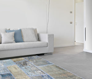 Tapis carré patchwork recyclé en laine et coton bleu vert beige intégré dans un intérieur salon moderne