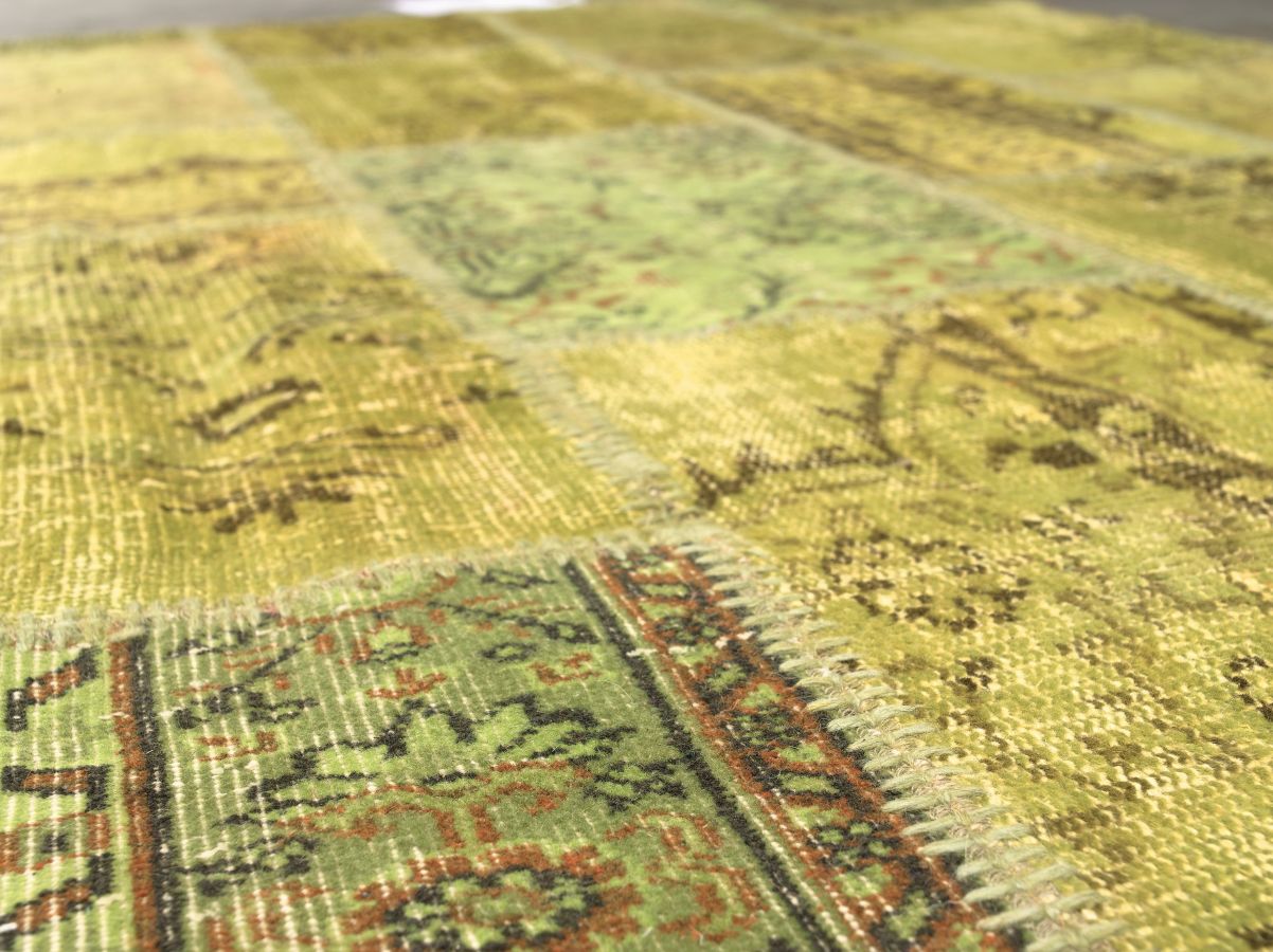 Zoom sur les motifs du tapis patchwork recyclé en laine coton — détail des textures vert jaune marron