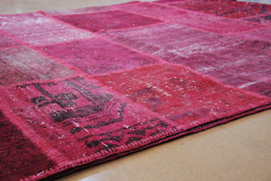Détail d’un bord du tapis patchwork recyclé en laine et coton rose rouge – texture et finitions