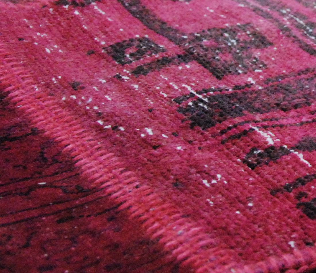 Zoom sur les motifs et la texture du tapis patchwork recyclé laine coton rose rouge