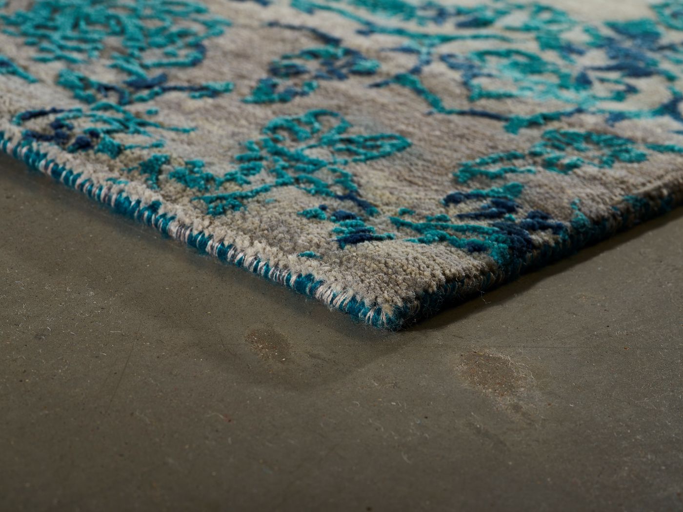 Tapis baroque gris bleu en laine et soie — angle de vue soulignant l’épaisseur, le relief du motif et la qualité artisanale