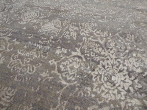 Gros plan sur le tapis floral ancien en laine et soie gris beige — texture soyeuse et motif finement travaillé