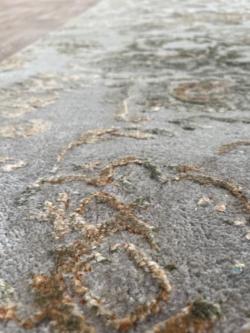 Gros plan sur les fibres du tapis de couloir laine et soie gris or – détails du motif et éclat luxueux de la texture