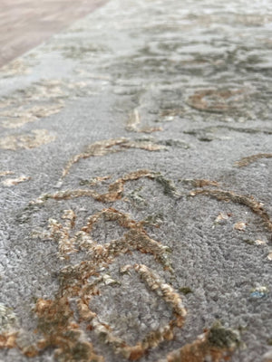 Gros plan sur les fibres du tapis de couloir laine et soie gris or – détails du motif et éclat luxueux de la texture