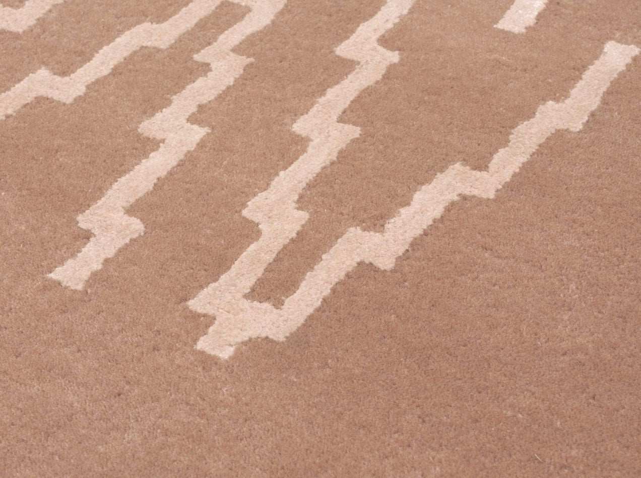 Gros plan sur les fibres laine–viscose du tapis rose pâle mettant en valeur la texture et le motif zigzag