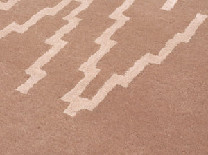 Gros plan sur les fibres laine–viscose du tapis rose pâle mettant en valeur la texture et le motif zigzag