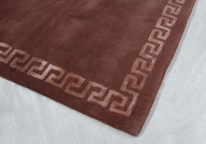 Tapis marron bronze à motifs grecs vu en angle, détails de texture en viscose et laine