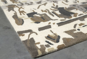 Coin du tapis graphique beige brun en laine et viscose, motif foule en perspective, texture et finitions visibles