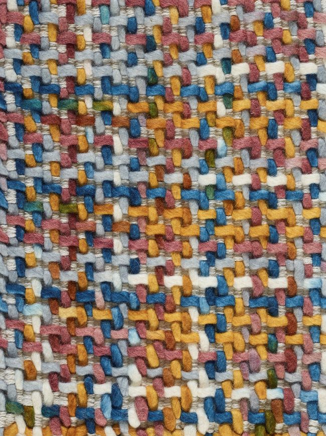 Zoom sur la texture du tapis en laine, montrant détails du motif tweed-tartan, couleurs pastel et qualité de tissage