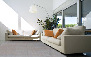 Tapis gris et orange tissé main en laine et viscose – intégré dans un salon contemporain, apportant chaleur et contraste