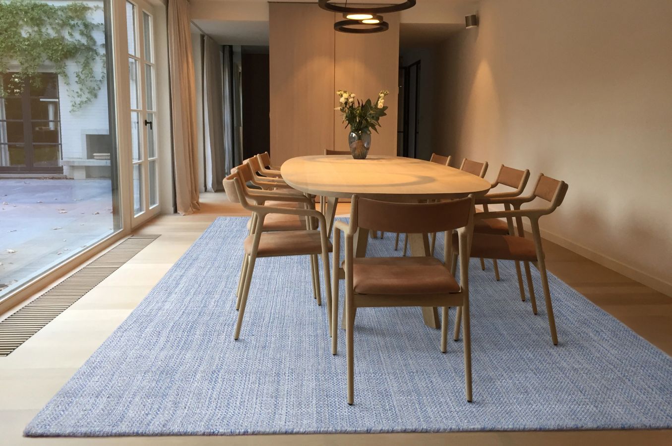 Tapis gris et bleu tissé main en laine et viscose, intégré dans une salle à manger élégante au style contemporain