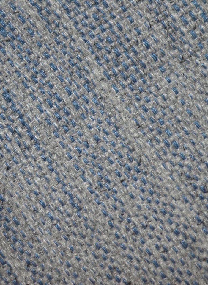 Détail du tapis gris et bleu tissé main – gros plan sur la texture en laine et viscose et les nuances subtiles du tissage