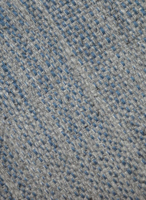 Détail du tapis gris et bleu tissé main – gros plan sur la texture en laine et viscose et les nuances subtiles du tissage