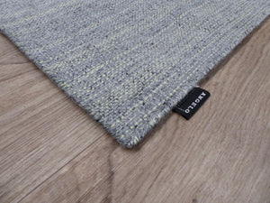 Tapis gris jaune artisanal en laine et viscose – vue en coin montrant les finitions et la trame tissée main