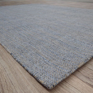 Vue en angle du tapis gris et beige tissé main, soulignant les détails du tissage artisanal et les nuances de couleurs