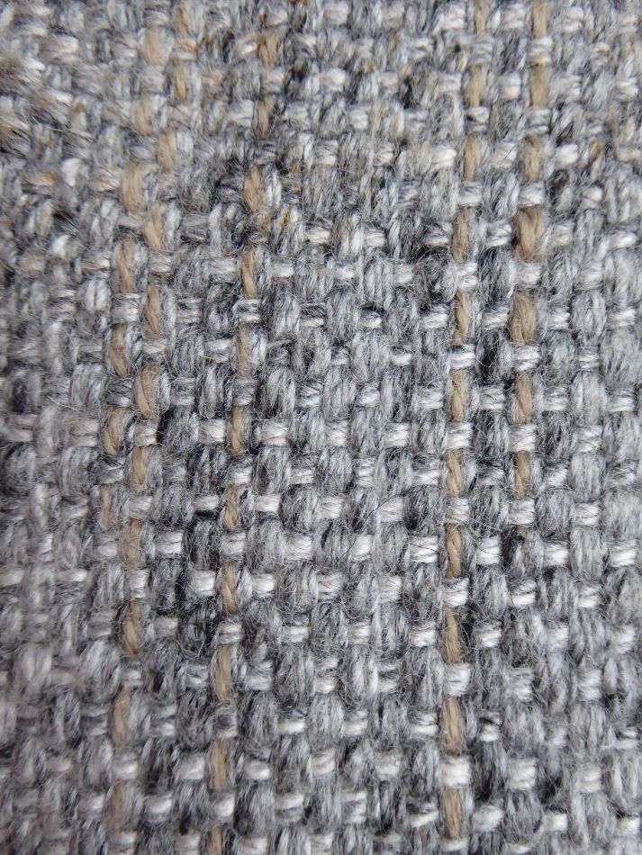 Gros plan sur la texture du tapis gris et beige tissé main, mettant en valeur les fibres naturelles de laine et de viscose