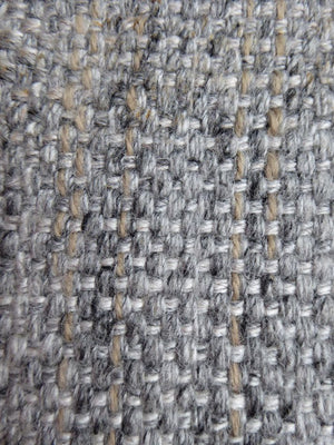 Gros plan sur la texture du tapis gris et beige tissé main, mettant en valeur les fibres naturelles de laine et de viscose