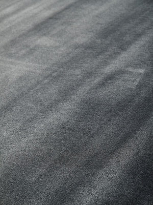 Gros plan sur les fibres brillantes d’un tapis gris soyeux en viscose