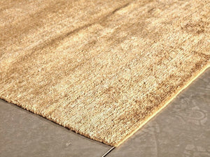 Tapis en soie de bambou jaune beige capturé en angle, mettant en valeur la douceur du velours et l’éclat doré