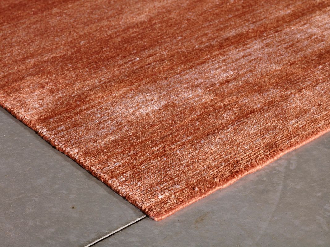 Tapis soyeux en soie de bambou terracotta,  angle montrant épaisseur, qualité de la finition et douceur