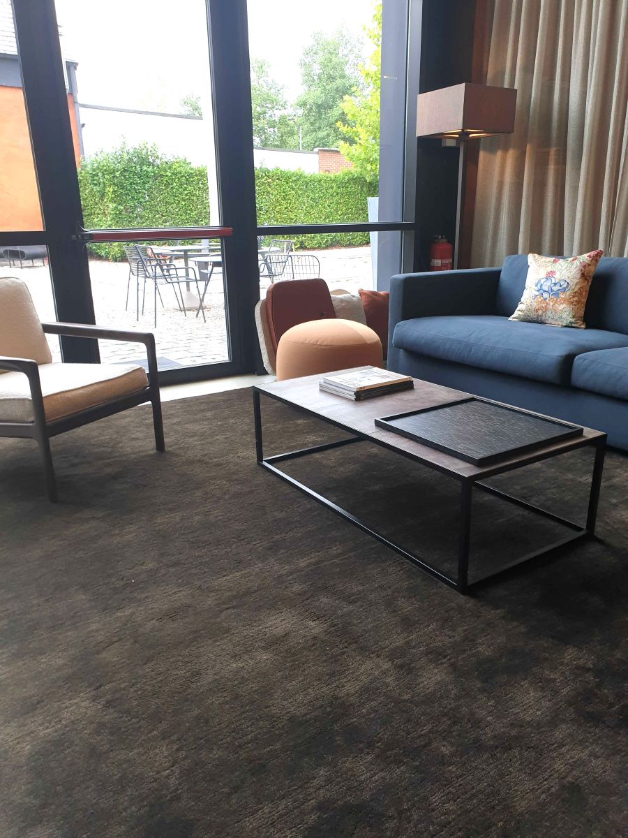 Tapis brun gris foncé en laine tissé main, intégré dans un salon contemporain, apportant chaleur et élégance à la pièce