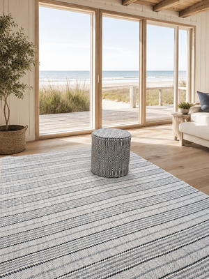 Tapis rectangulaire en laine Tartan SPL/2, motif rayé tartan gris et écru, présenté dans un intérieur lumineux en bord de mer.