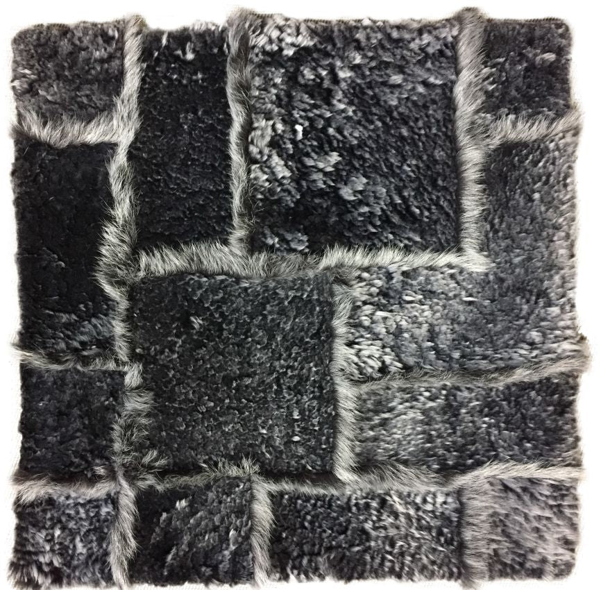 Gros plan sur la texture du tapis gris foncé en laine d’agneau, poil long et court, richesse du tissage et la douceur