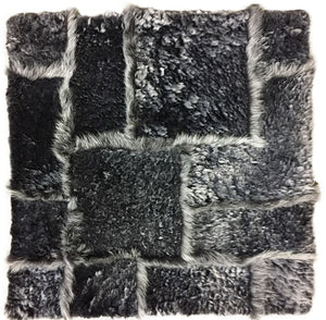 Gros plan sur la texture du tapis gris foncé en laine d’agneau, poil long et court, richesse du tissage et la douceur