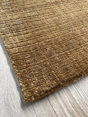 Tapis marron et or durable en PET recyclé, motif carreaux discret, vue en perspective depuis le coin