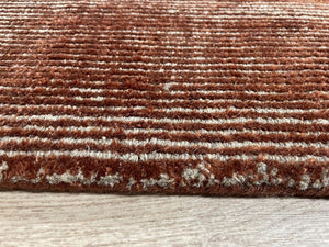 Tapis terracotta beige brillant, vu de côté – met en valeur les nuances chaudes et la texture luxueuse du tissage