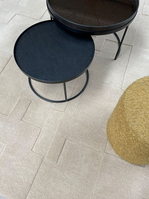 Tapis blanc cassé à motifs géométriques en relief, harmonisé avec un mobilier moderne et épuré