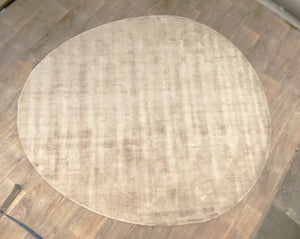 Tapis rond beige en viscose, vue de face – surface lisse et brillante, texture luxueuse et élégante