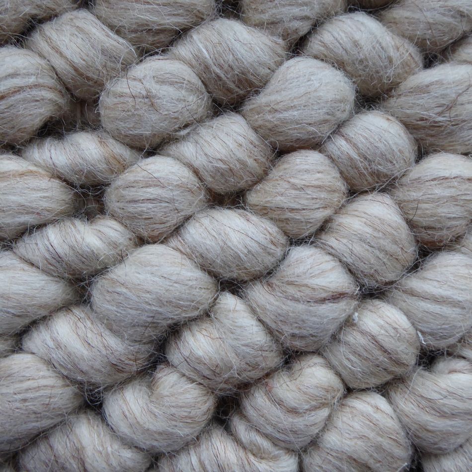 Zoom sur la texture bouclée en laine feutrée du tapis beige blanc, relief unique et toucher doux