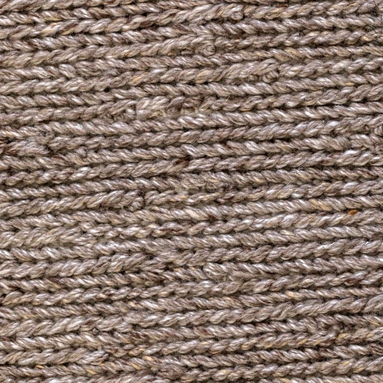 Gros plan sur la texture du tapis gris taupe en PET recyclé, fibres résistantes pour usage intérieur et extérieur
