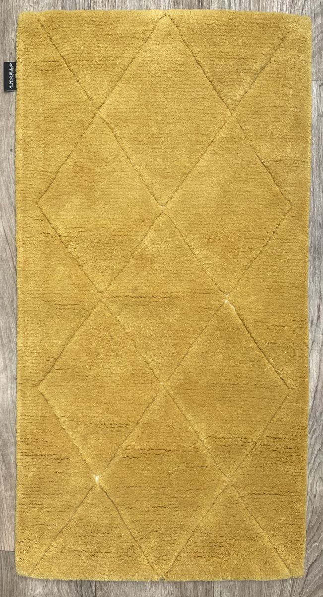 Petit tapis jaune doux en laine motif losange vu de face, posé sur un sol clair