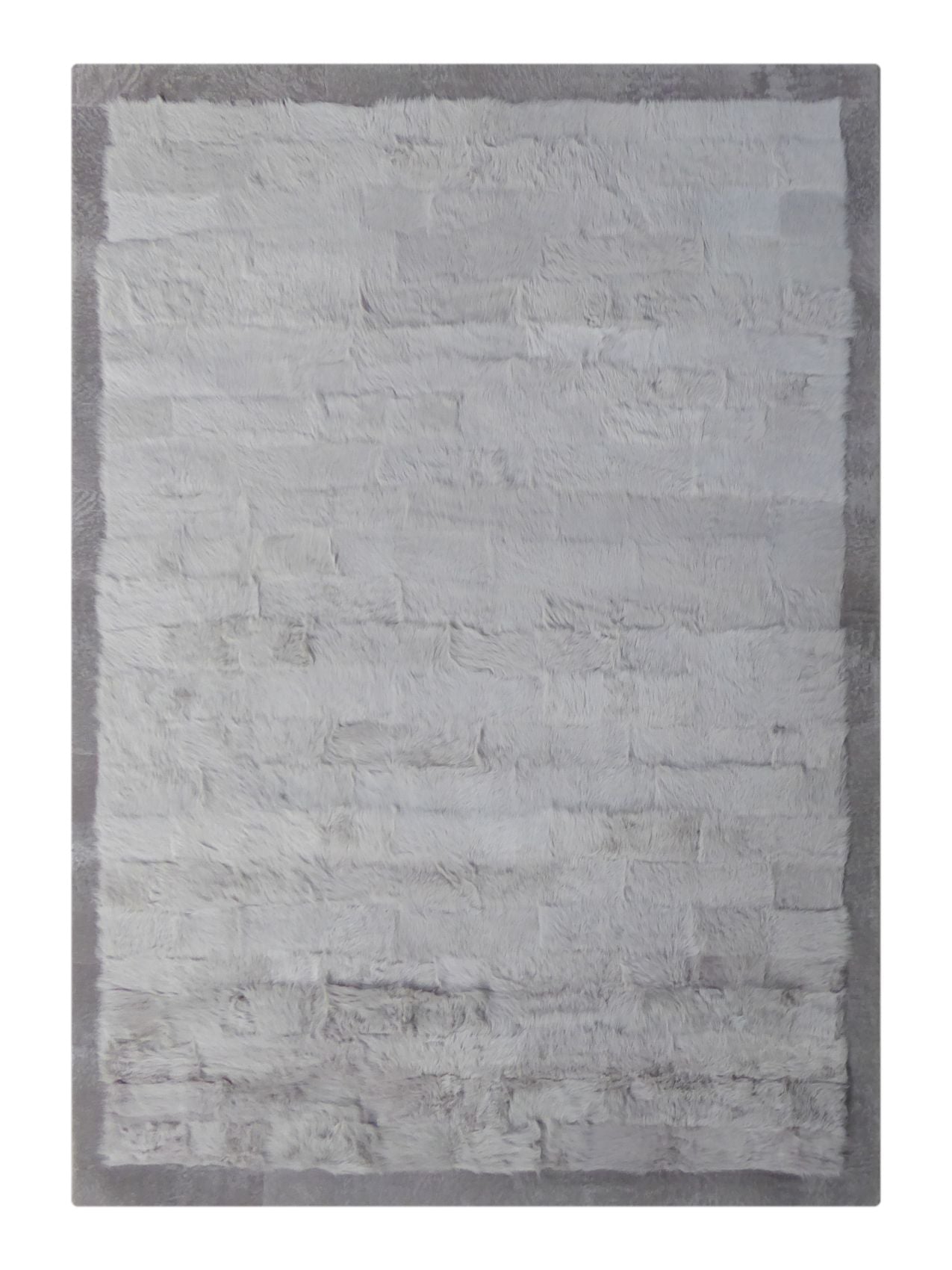 Tapis gris clair en laine d’agneau à poils longs avec bord foncé – vue de face montrant la texture douce