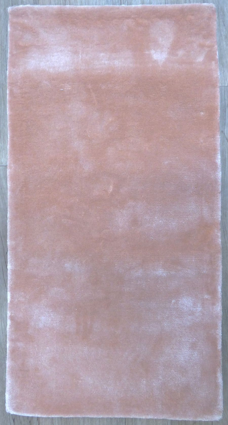 Tapis en viscose couleur pêche rose vu de face, texture douce et surface lisse