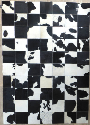 Tapis audacieux en cuir de vachette, motifs géométriques damier peau de vache gris ivoire noir, vue de face