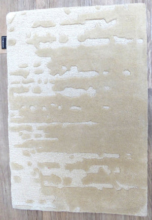 Tapis ivoire en laine et viscose, motifs abstraits en relief, vue de face montrant la texture et les contrastes subtils