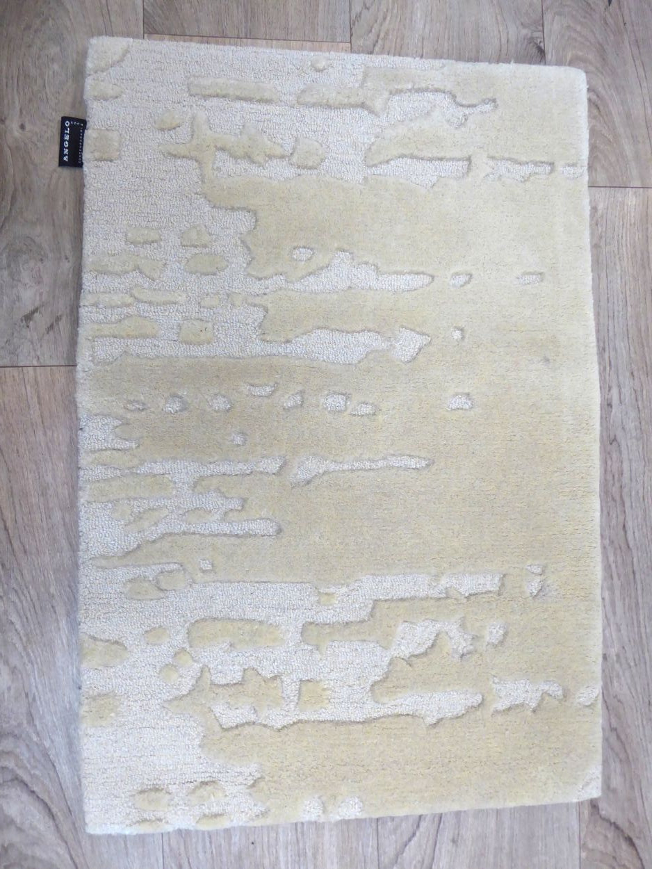 Tapis ivoire en laine et viscose, à motifs abstraits en relief, vue de face sur sol neutre