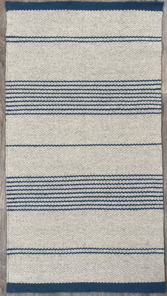 Tapis tissé main beige à rayures marine, présenté de face sur fond neutre