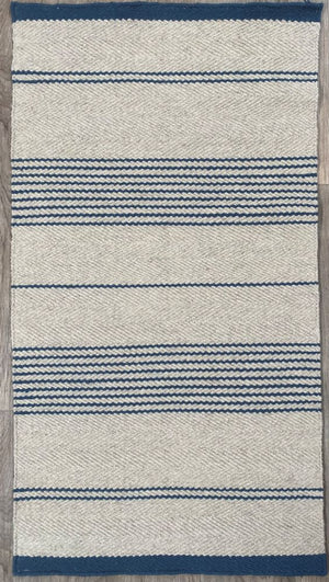 Tapis tissé main beige à rayures marine, présenté de face sur fond neutre