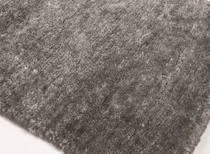 Tapis en soie de bambou gris marron présenté de coin, mettant en valeur sa finesse et sa douceur au toucher