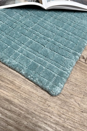 Tapis bleu durable tissé à la main en PET recyclé, motif carreaux visible depuis un angle en coin