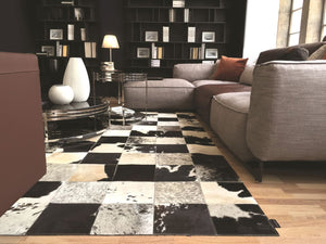 Tapis en cuir de vachette damier gris ivoire noir intégré dans un salon moderne, ambiance chaleureuse