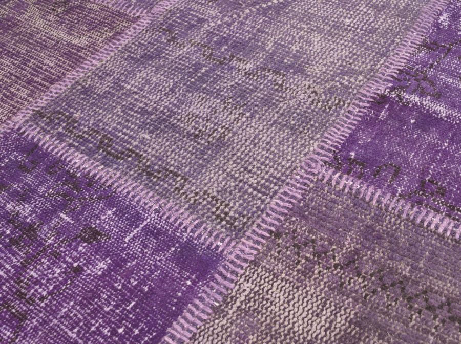 Gros plan sur les détails du textile et des motifs du tapis patchwork recyclé laine et coton violet